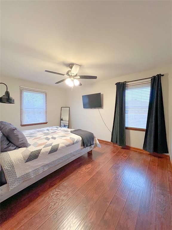 bedroom featuring a ceiling fan, baseboards, and wood-type flooring