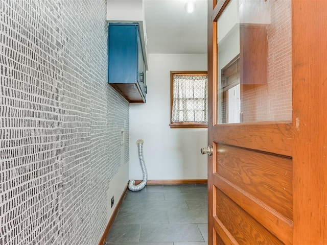 clothes washing area featuring tile patterned floors and baseboards