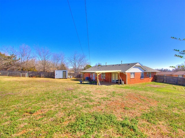 view of yard featuring an outbuilding, a storage unit, and a fenced backyard