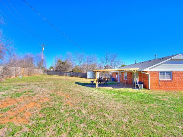 view of yard with an outbuilding, a fenced backyard, and a patio area