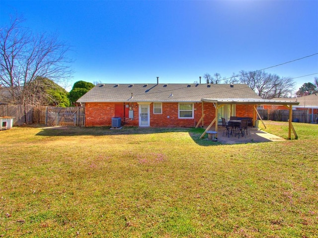 back of property with a lawn, central AC, a fenced backyard, and a patio area