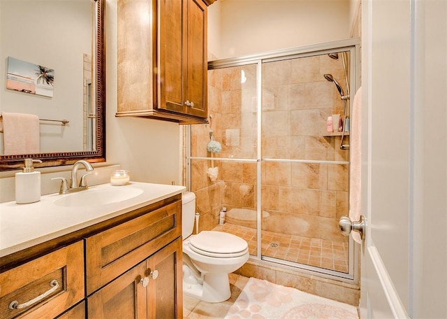 full bathroom featuring a stall shower, toilet, and vanity