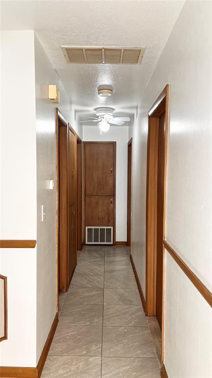 3731 Newport St, Oklahoma City, OK 73112 - hall with baseboards, visible vents, and a textured ceiling