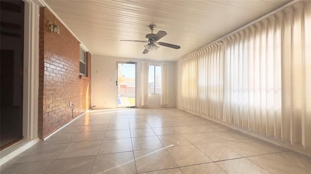 3731 Newport St, Oklahoma City, OK 73112 - empty room with a ceiling fan, light tile patterned floors, and brick wall
