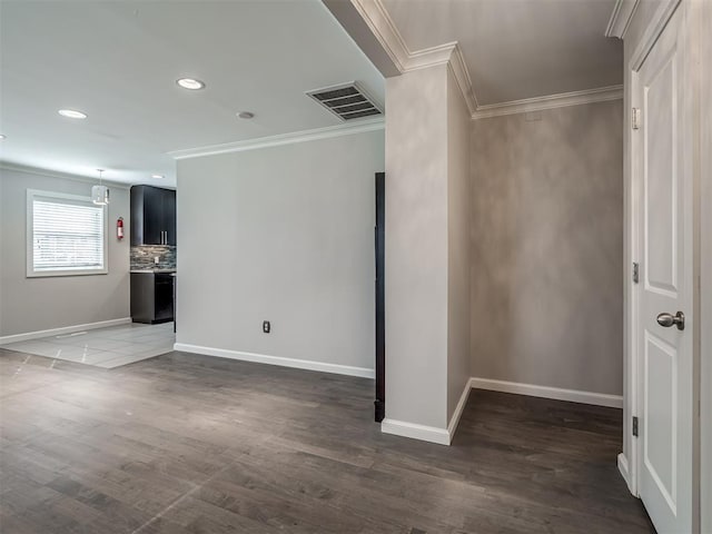 interior space with crown molding, baseboards, and visible vents