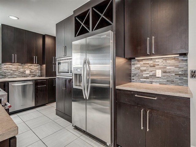 kitchen with tasteful backsplash, dark brown cabinets, stainless steel appliances, and light countertops