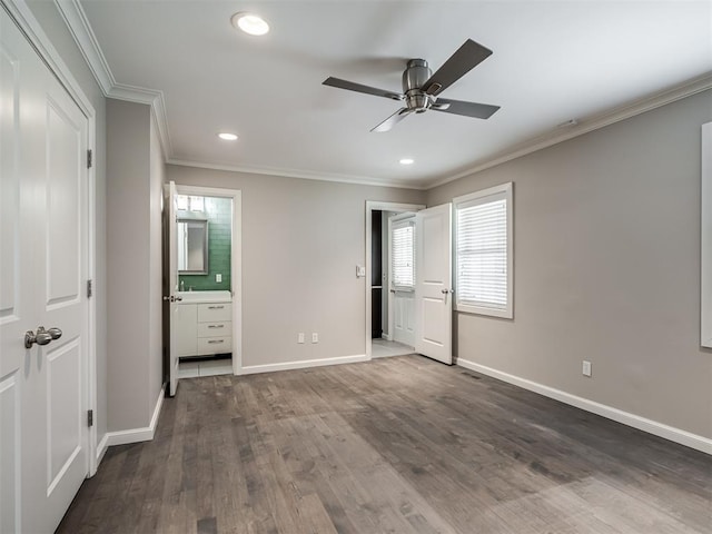 unfurnished bedroom with ensuite bath, dark wood finished floors, recessed lighting, crown molding, and baseboards