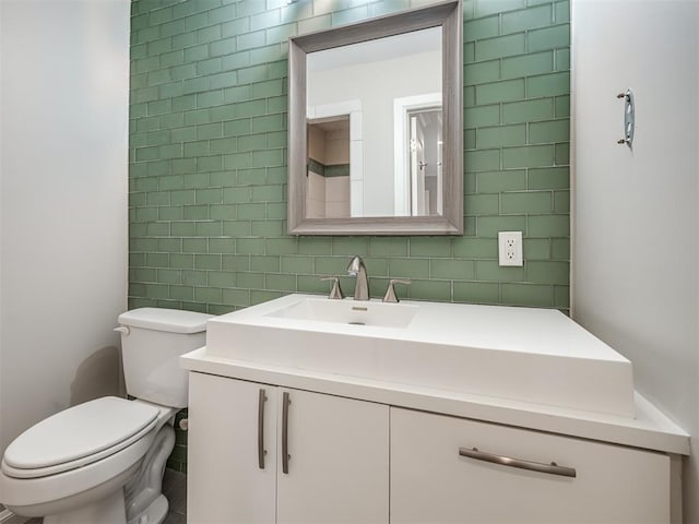 bathroom with vanity, toilet, and tile walls