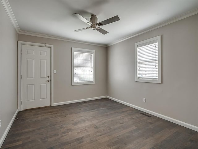 empty room featuring dark wood finished floors, ornamental molding, baseboards, and ceiling fan