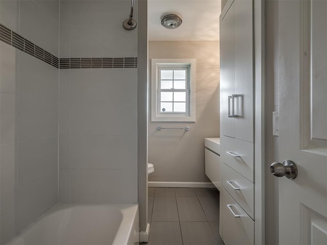 bathroom with baseboards, toilet, and tile patterned flooring