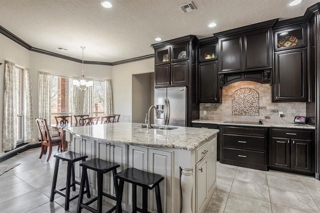 2241 W Mickey Dr, Mustang, OK 73064 - kitchen featuring tasteful backsplash, a sink, stainless steel fridge, an inviting chandelier, and visible vents