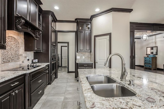 2241 W Mickey Dr, Mustang, OK 73064 - kitchen featuring oven, a sink, tasteful backsplash, light stone counters, and black electric stovetop