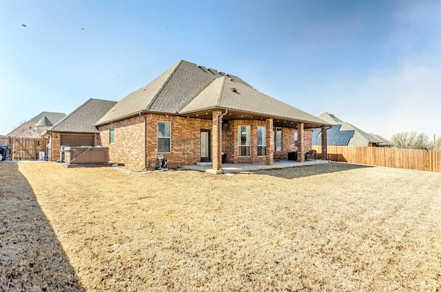 2241 W Mickey Dr, Mustang, OK 73064 - back of house featuring a fenced backyard, a shingled roof, brick siding, and a patio