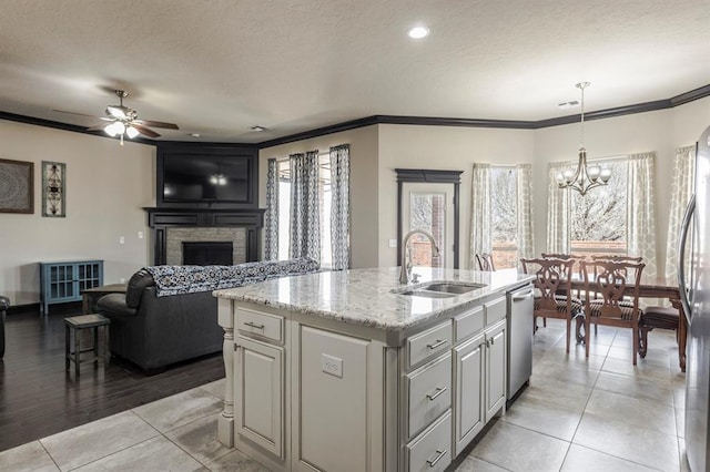 2241 W Mickey Dr, Mustang, OK 73064 - kitchen featuring stainless steel appliances, a sink, open floor plan, a stone fireplace, and ornamental molding