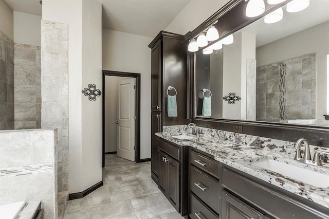 2241 W Mickey Dr, Mustang, OK 73064 - bathroom featuring baseboards, double vanity, a walk in shower, and a sink