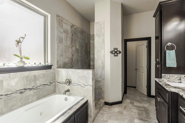 2241 W Mickey Dr, Mustang, OK 73064 - bathroom featuring baseboards, a jetted tub, vanity, and a tile shower