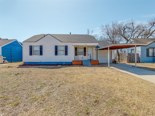 view of front of home featuring fence, driveway, a front lawn, a carport, and a garage