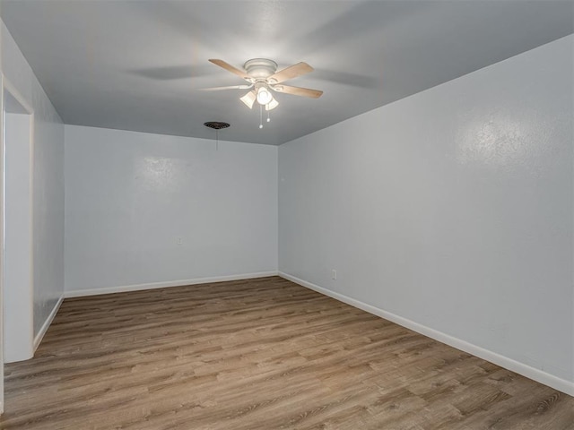 empty room with wood finished floors, baseboards, and ceiling fan