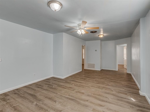 unfurnished room featuring baseboards, wood finished floors, visible vents, and ceiling fan