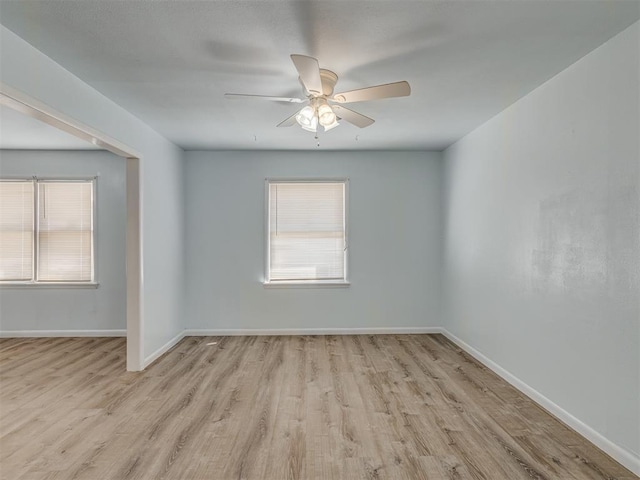 spare room featuring wood finished floors, plenty of natural light, and a ceiling fan