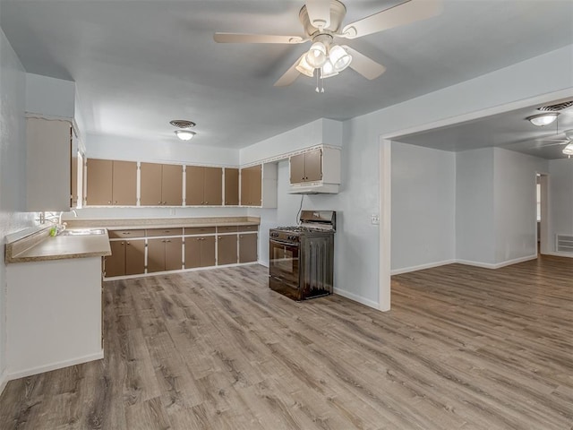 kitchen featuring light wood-style flooring, a ceiling fan, and black gas stove