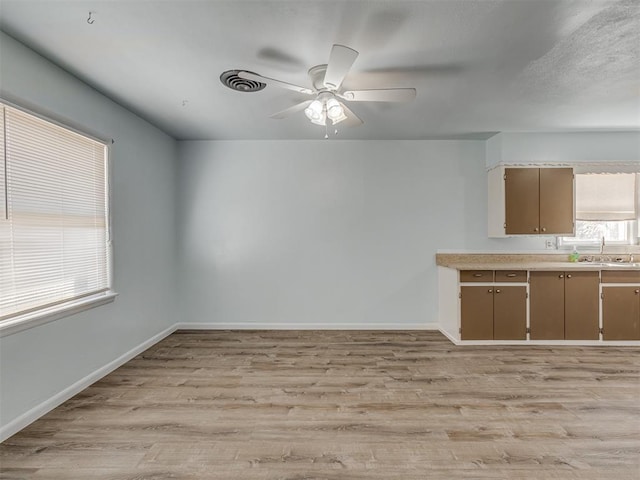 kitchen featuring visible vents, baseboards, light wood-style flooring, and light countertops