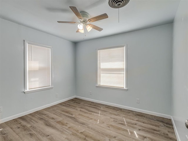 spare room with a ceiling fan, wood finished floors, and baseboards