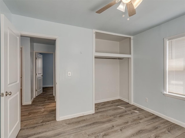 unfurnished bedroom with a ceiling fan, wood finished floors, baseboards, and a closet