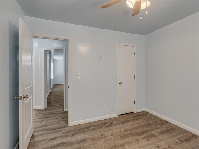 unfurnished bedroom with a ceiling fan, baseboards, and wood finished floors