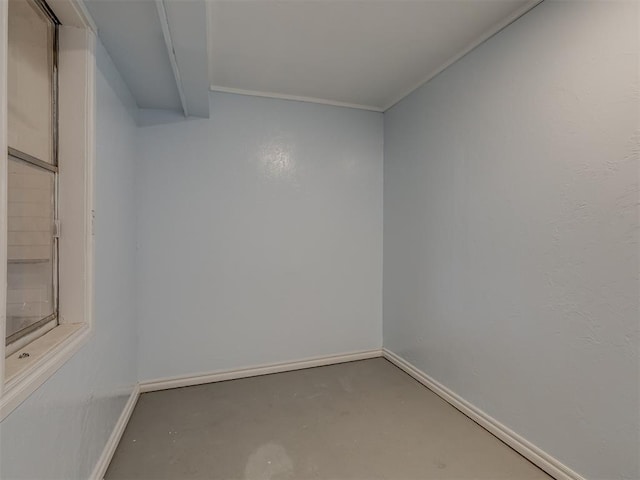 unfurnished room featuring concrete flooring and baseboards