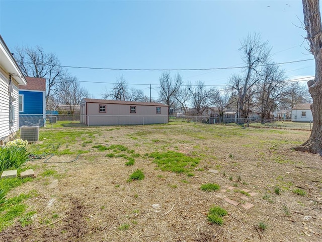 view of yard featuring fence and central AC