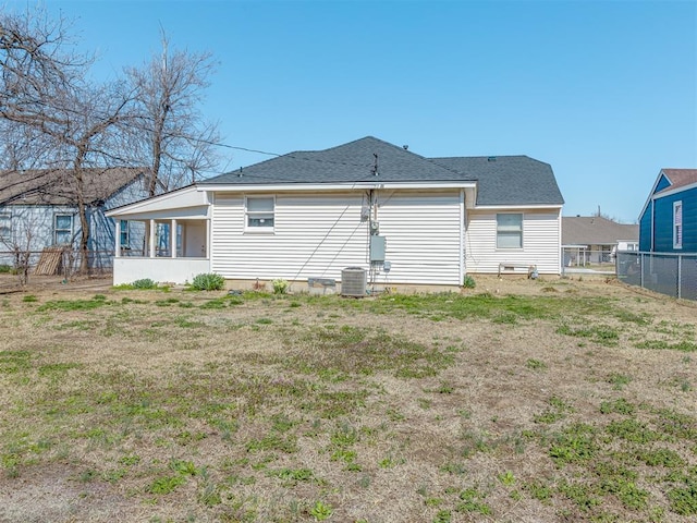 back of house with central air condition unit, fence, and a shingled roof