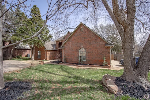 view of front of house featuring a front lawn, fence, and brick siding