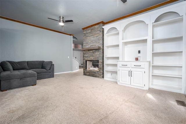 living area with visible vents, light colored carpet, ornamental molding, a stone fireplace, and a ceiling fan