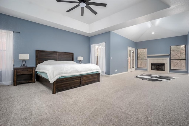 bedroom featuring a ceiling fan, baseboards, lofted ceiling, a tiled fireplace, and carpet flooring