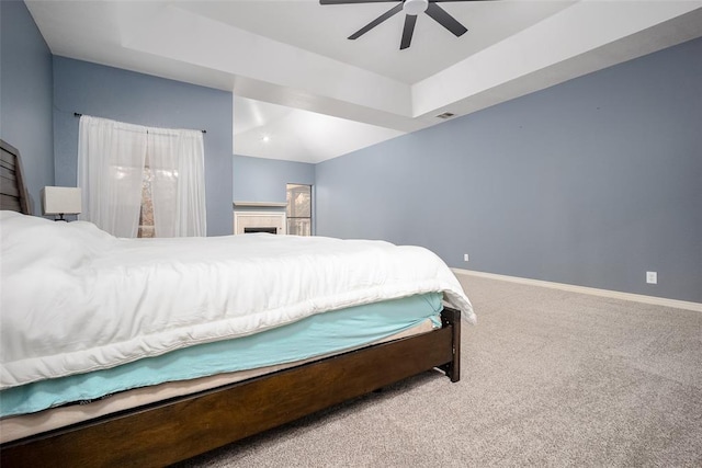 carpeted bedroom featuring visible vents, ceiling fan, a raised ceiling, and baseboards