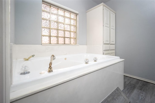 full bathroom featuring a garden tub and wood finished floors