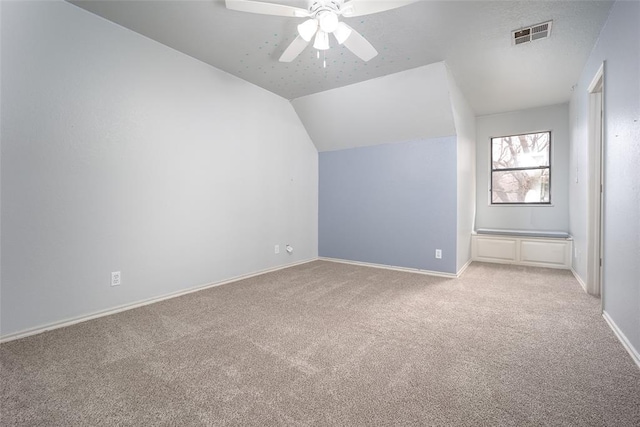 bonus room featuring visible vents, a ceiling fan, baseboards, lofted ceiling, and light colored carpet