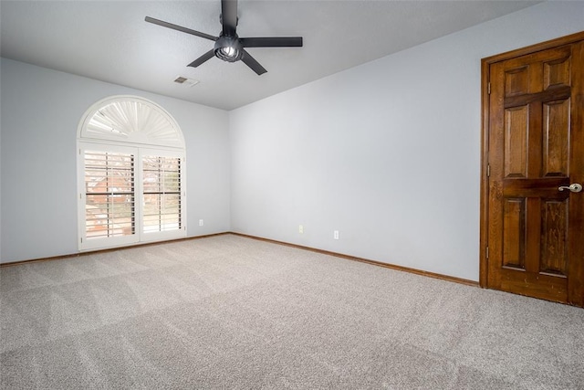 unfurnished room with a ceiling fan, visible vents, light colored carpet, and baseboards