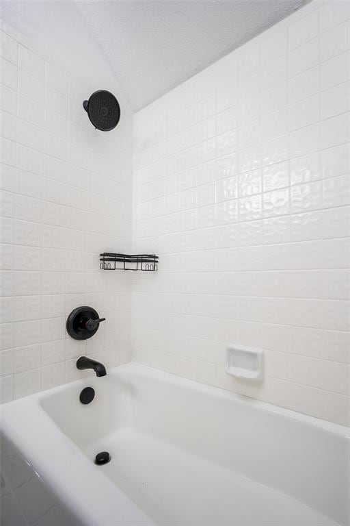 full bath featuring lofted ceiling and shower / tub combination