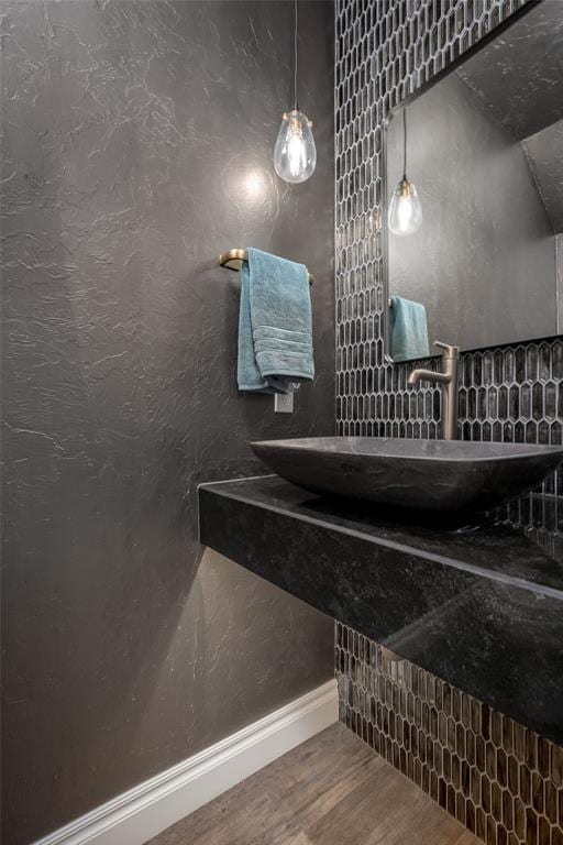 bathroom featuring a sink, baseboards, and wood finished floors