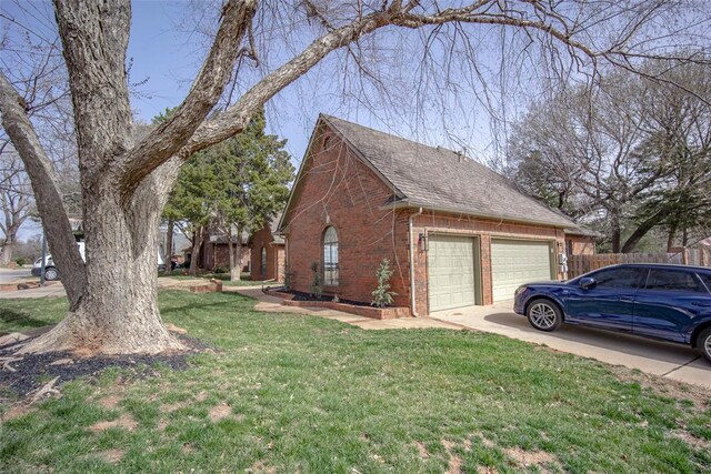 view of side of home featuring a yard, an attached garage, a shingled roof, concrete driveway, and brick siding