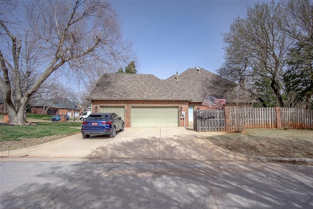 view of front facade with fence, an attached garage, a shingled roof, concrete driveway, and brick siding