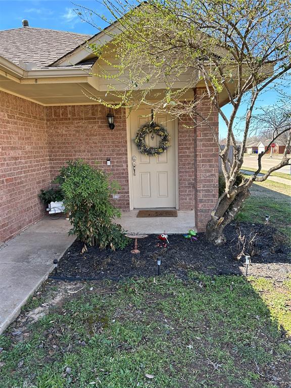 view of exterior entry with brick siding