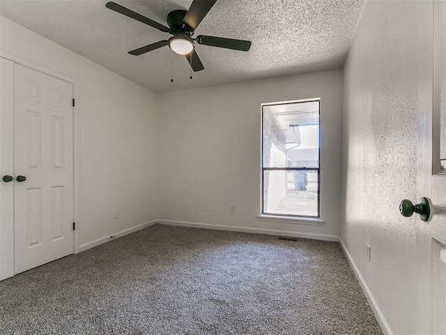 unfurnished room with baseboards, a textured ceiling, a ceiling fan, and carpet floors