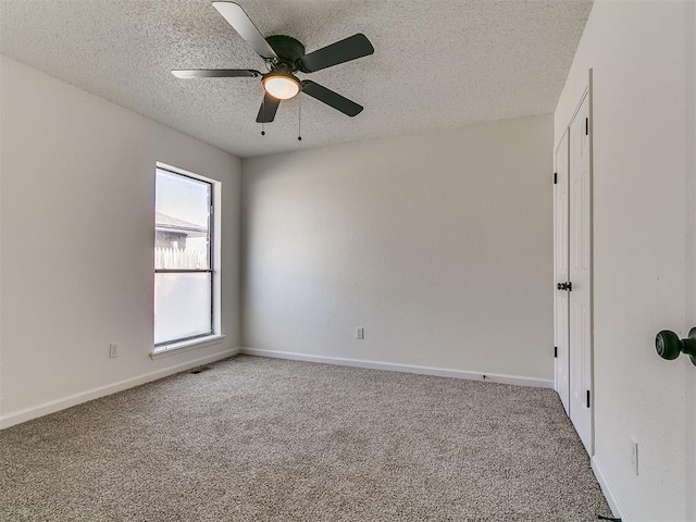 empty room with ceiling fan, baseboards, carpet floors, and a textured ceiling