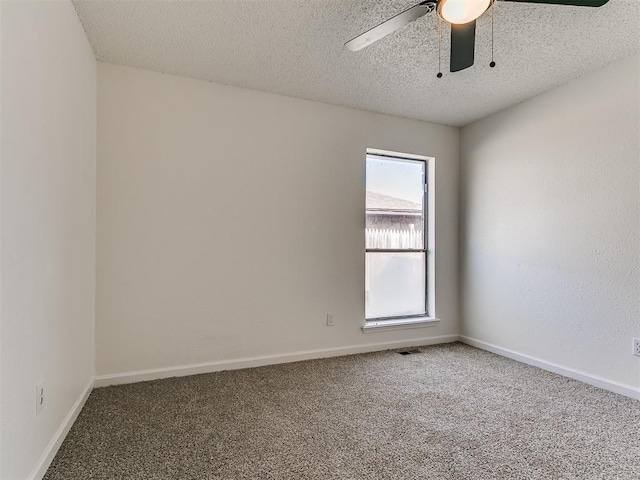 carpeted spare room with visible vents, baseboards, a textured ceiling, and ceiling fan