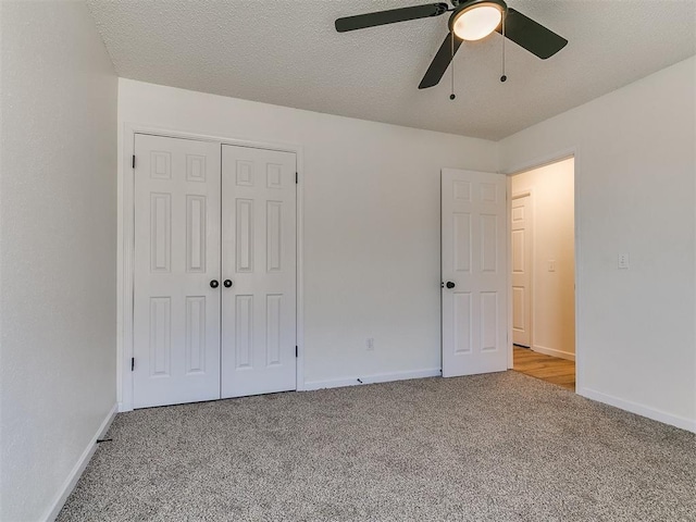 unfurnished bedroom with a closet, carpet flooring, a textured ceiling, and baseboards