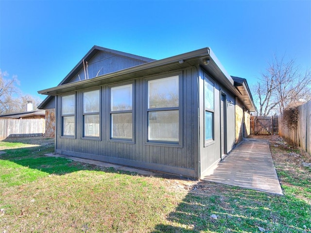 view of side of home with a yard and fence