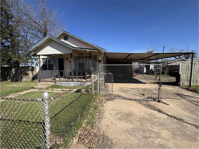 501 SE 15th St, Oklahoma City, OK 73129 - view of front of house with a front lawn, driveway, fence private yard, an attached carport, and a porch